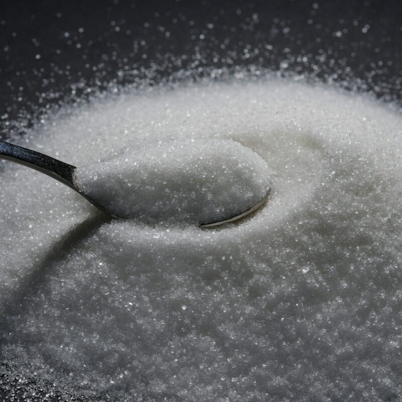 a tablespoon rests on a mountain of sugar